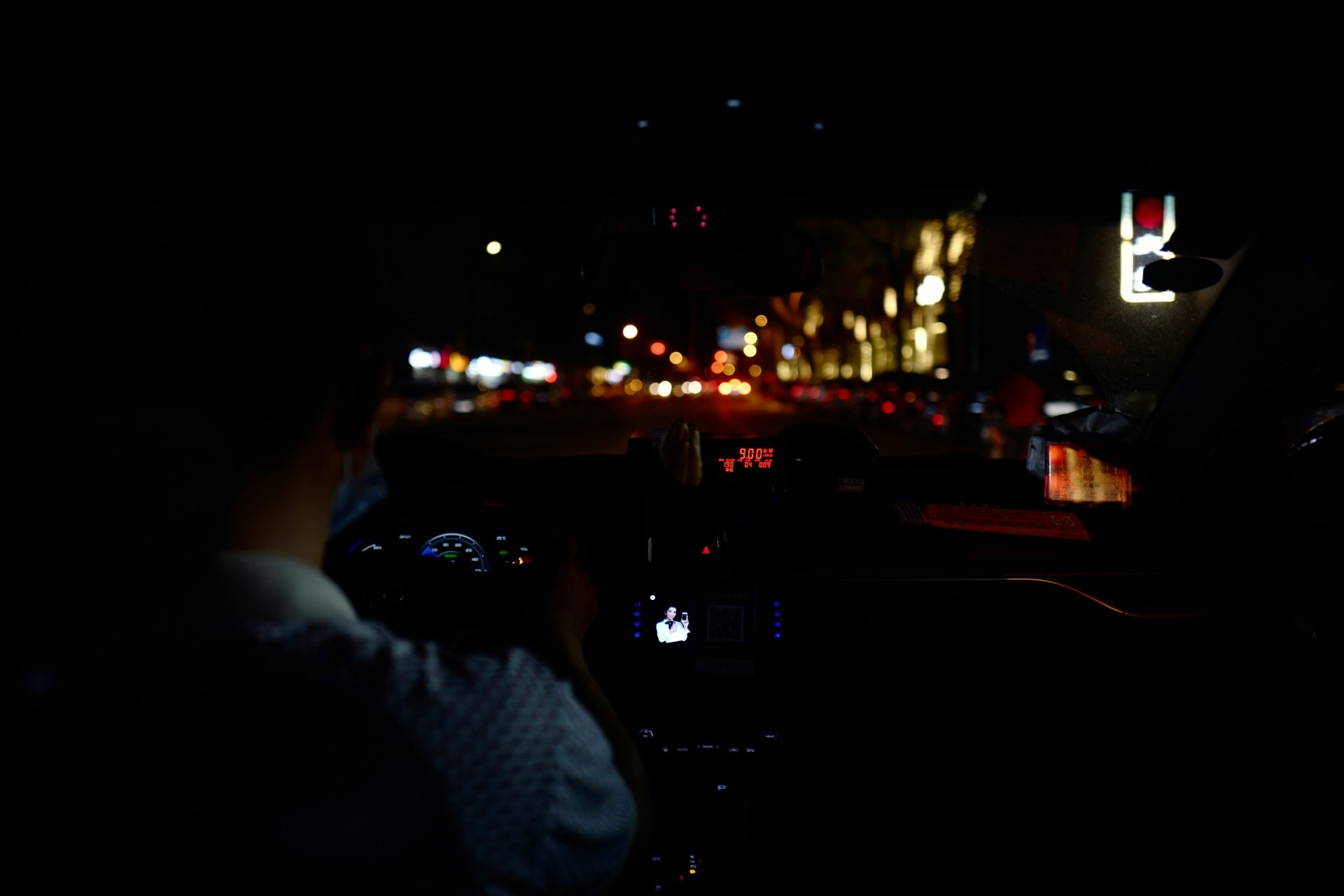 man in white and blue checkered dress shirt driving car during night time